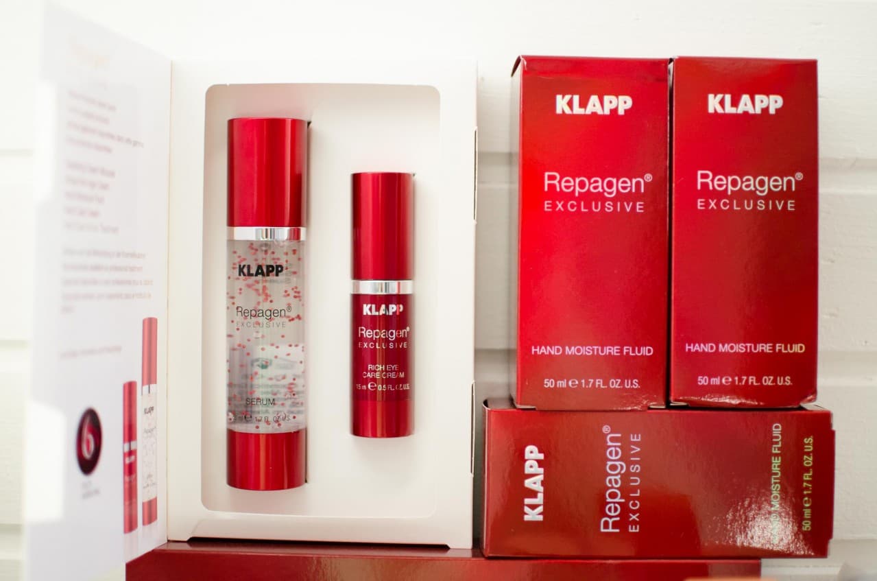 Rote Verpackungen und Spender der KLAPP-Linie Repagen Exclusive, darunter Serum und Augencreme