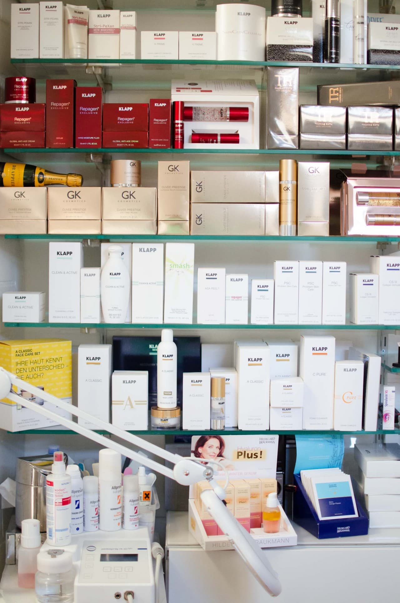 Glasregal voller Pflegeprodukte, unten ein Aufsteller von Hildegard Braukmann